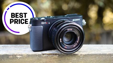 A Sony RX1R camera with a Zeiss lens rests on a wooden surface, accompanied by a "Best Price" label