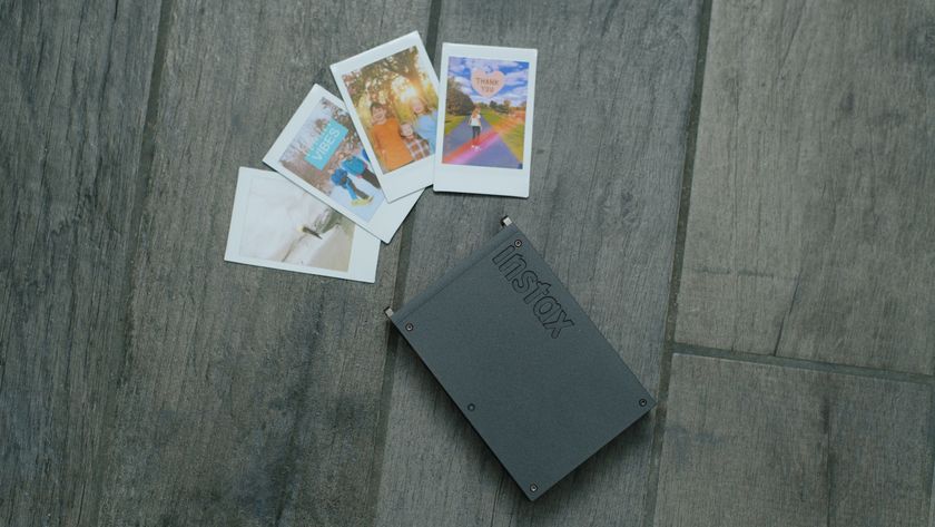 The Fujifilm Instax Mini Link+ on a gray background with instant prints