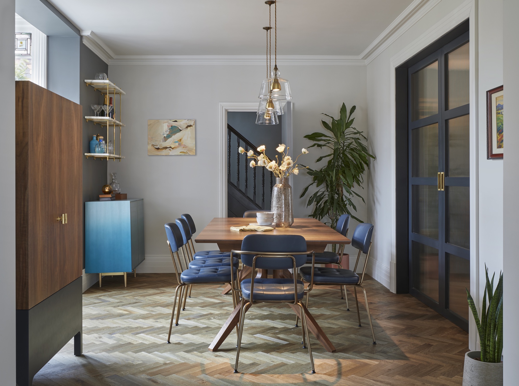 modern dining room with plants and drinks cabinet by Cherie Lee