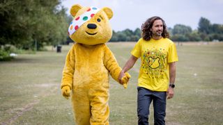 Pudsey Bear holding hands with Joe Wicks