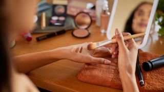 woman blending makeup on hand