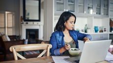 Woman checks her time as she is sat down about to eat