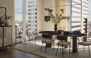 A minimal light fixture hangs above a dining room table in the corner of an apartment in Manhattan