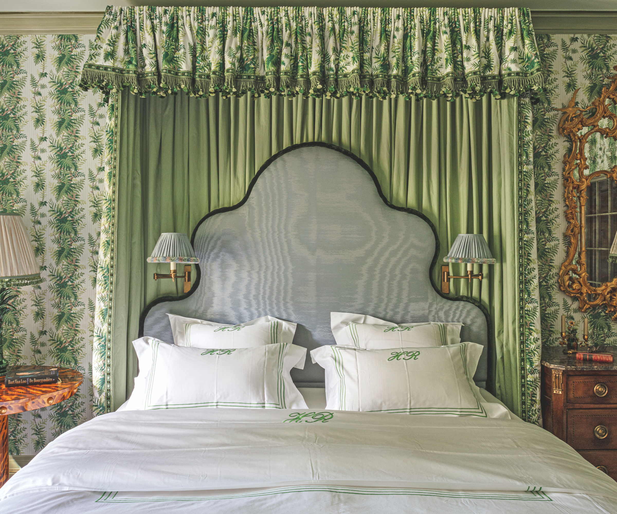 a green bedroom with floral fabric canopy