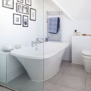 white bathroom with bathtub and gallery wall
