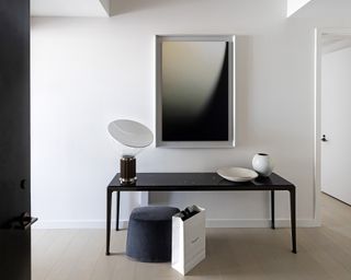 An entryway with white walls and a black console table