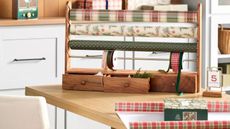 Wood and brass gift wrap holder with red and green plaid gift wrap