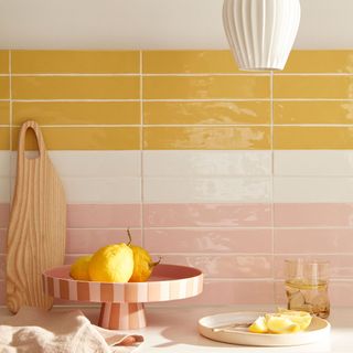 Close up of yellow, white and pink glazed kitchen wall tiles
