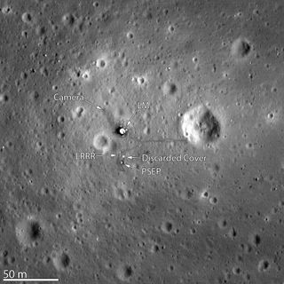 a photograph of several large craters on a grey dusty surface