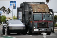 Tesla Cybertruck alongside a garbage truck