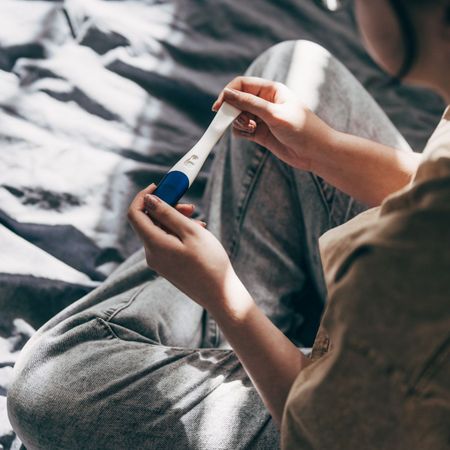 Rear View Cropped Shot Of Unrecognizable Woman Taking Pregnancy Test At Home