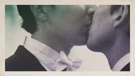 A close-cropped photo of two Asian men in wedding attire kissing. Their faces are obscured.