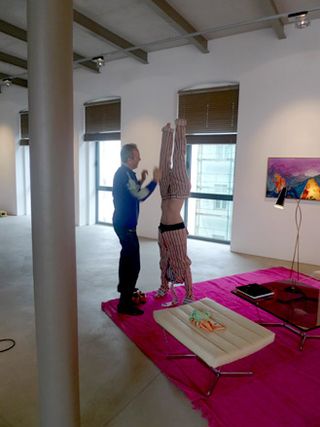 Edwin Wurm adjusting an outfit which makes the model appear as if they are doing a handstand