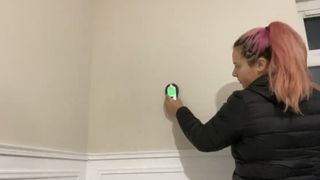 Using a stud and live wire detector on the wall