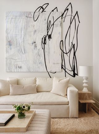 The cream and white family room, with a dramatic abstract wall art feature and white couch