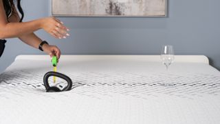 A weight next to wine glass on the Nectar Luxe mattress to test motion isolation