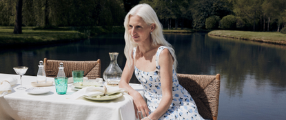 Woman at a garden party wearing a dress from NET-A-PORTER