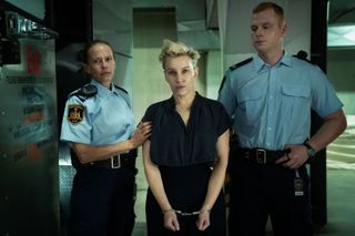 Kate Lawson in handcuffs with two police officers