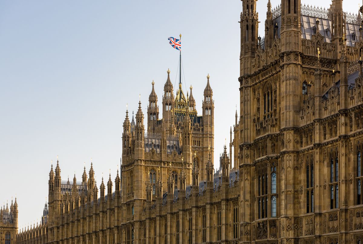 Westminster Parliament, home of the UK government, pictured during the day time with UK flag flying in background