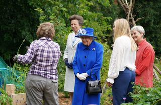 Queen Elizabeth II and Princess Anne, Princess Royal visit the Children's Wood Project, a community project in Glasgow as part of her traditional trip to Scotland for Holyrood Week on June 30, 2021