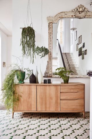 white hallway with wooden console and large mirror