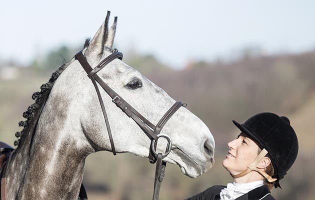 Harriet Fairhurst and horse Hazel. show cover, kissing horse, bonding with horse,cuddle,rosette,showing head,grey horse,hunter