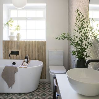 bathroom with window, white bath rub, wooden splashback and black taps