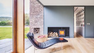 modern living room with leather chai9r and woodburning stove