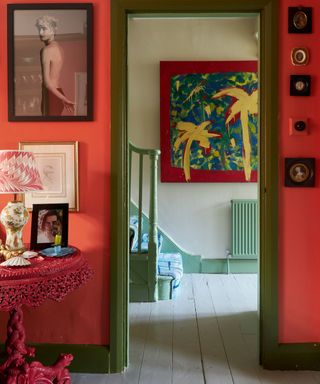 Red room with gallery wall looking through to a pale blue entryway