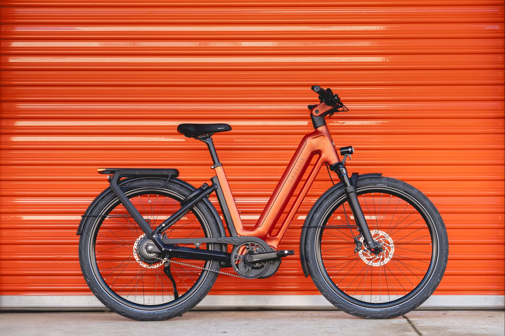 An orange Eclipse e-bike against an orange wall