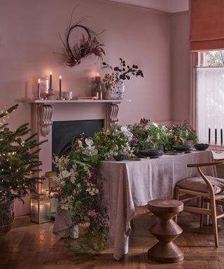 Pink dining room with big table garland and christmas decorations
