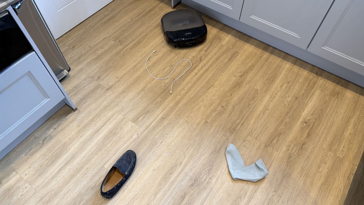 Eufy Omni S2 robot vacuum navigating a room with a shoe and a sock