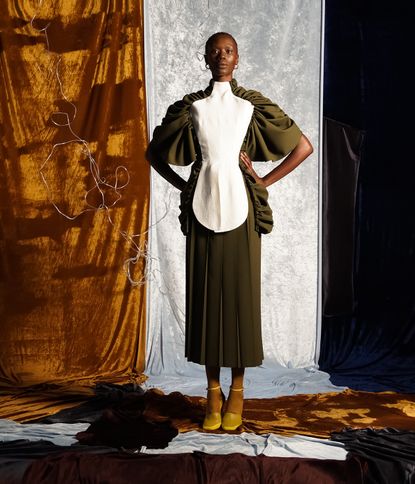 Woman in yellow outfit leaning on yellow chair