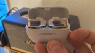 Bose Ultra Open Earbuds held in the hand