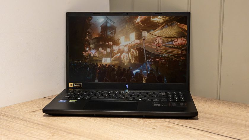 An Acer Nitro V15 (2025) on a wooden desk with the screen enabled and playing a game.