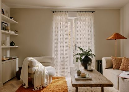 A living room with sheer curtains and decor