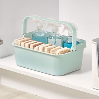 Blue under sink storage caddy filled with cleaning products