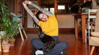 Woman stretching with cat in lap