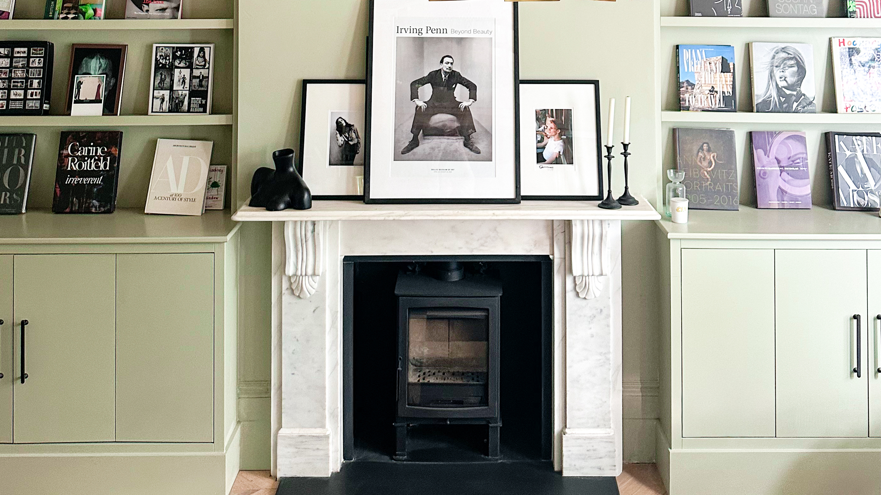 fireplace with pictures on the mantle and on shelves either side