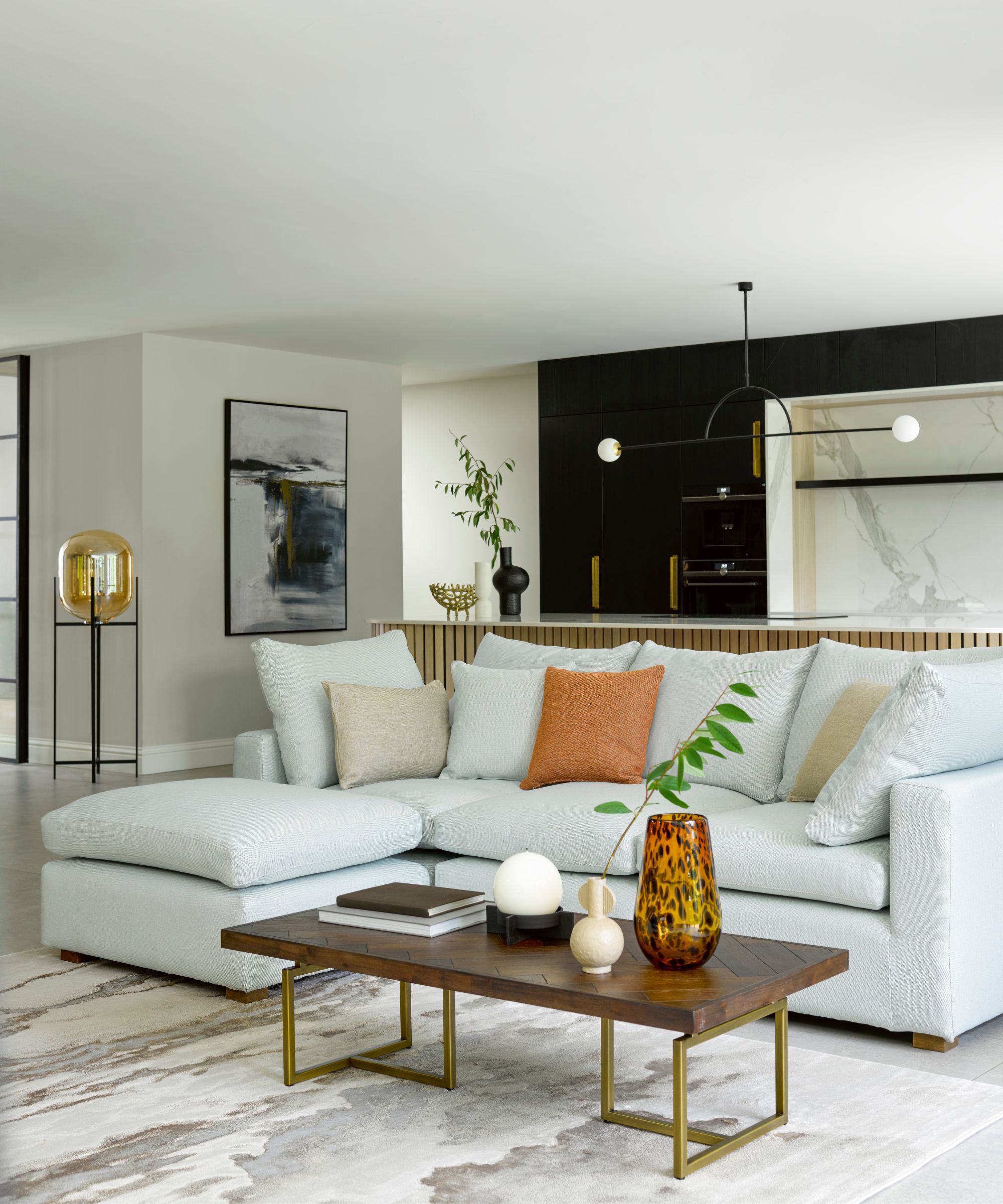 Living room with sectional sofa and kitchen behind