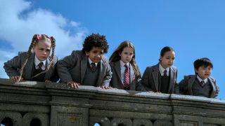 Matilda and her friends look down from a roof top in Matilda the Musical