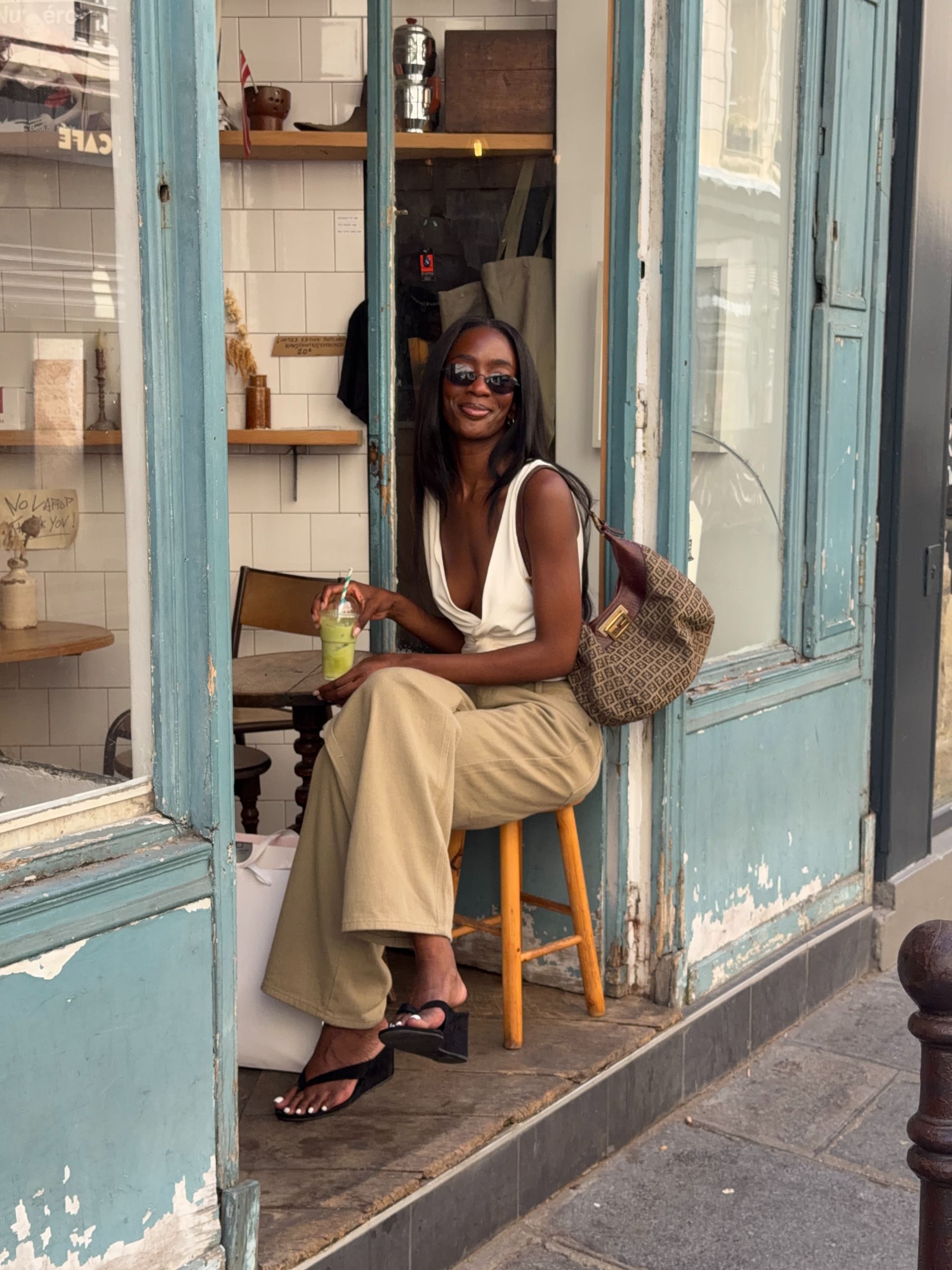 An image of @_livmadeline wearing khaki jeans with heeled flip-flop wedges and a white top.