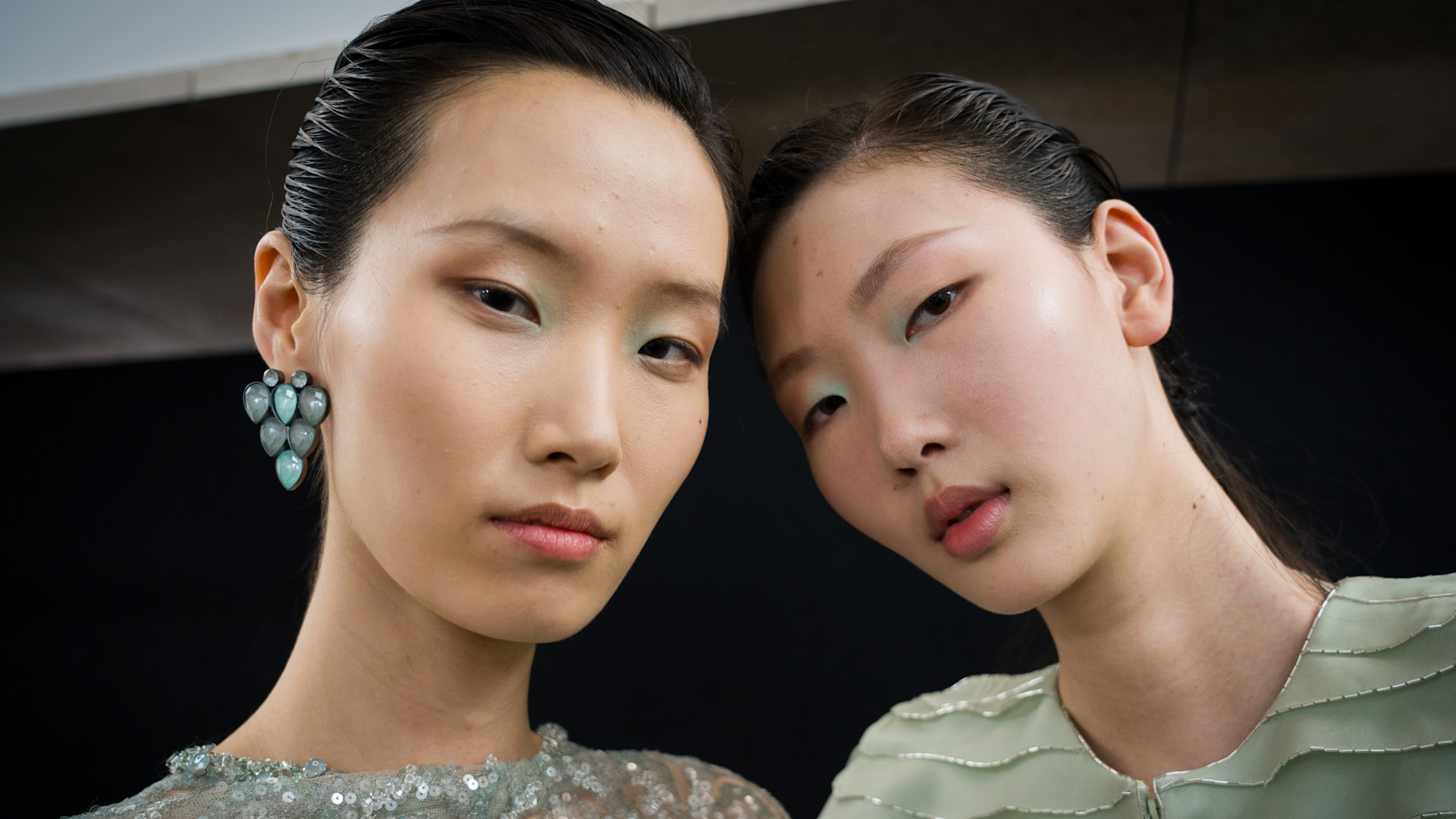 Two models with glowy, highlighted skin. 
