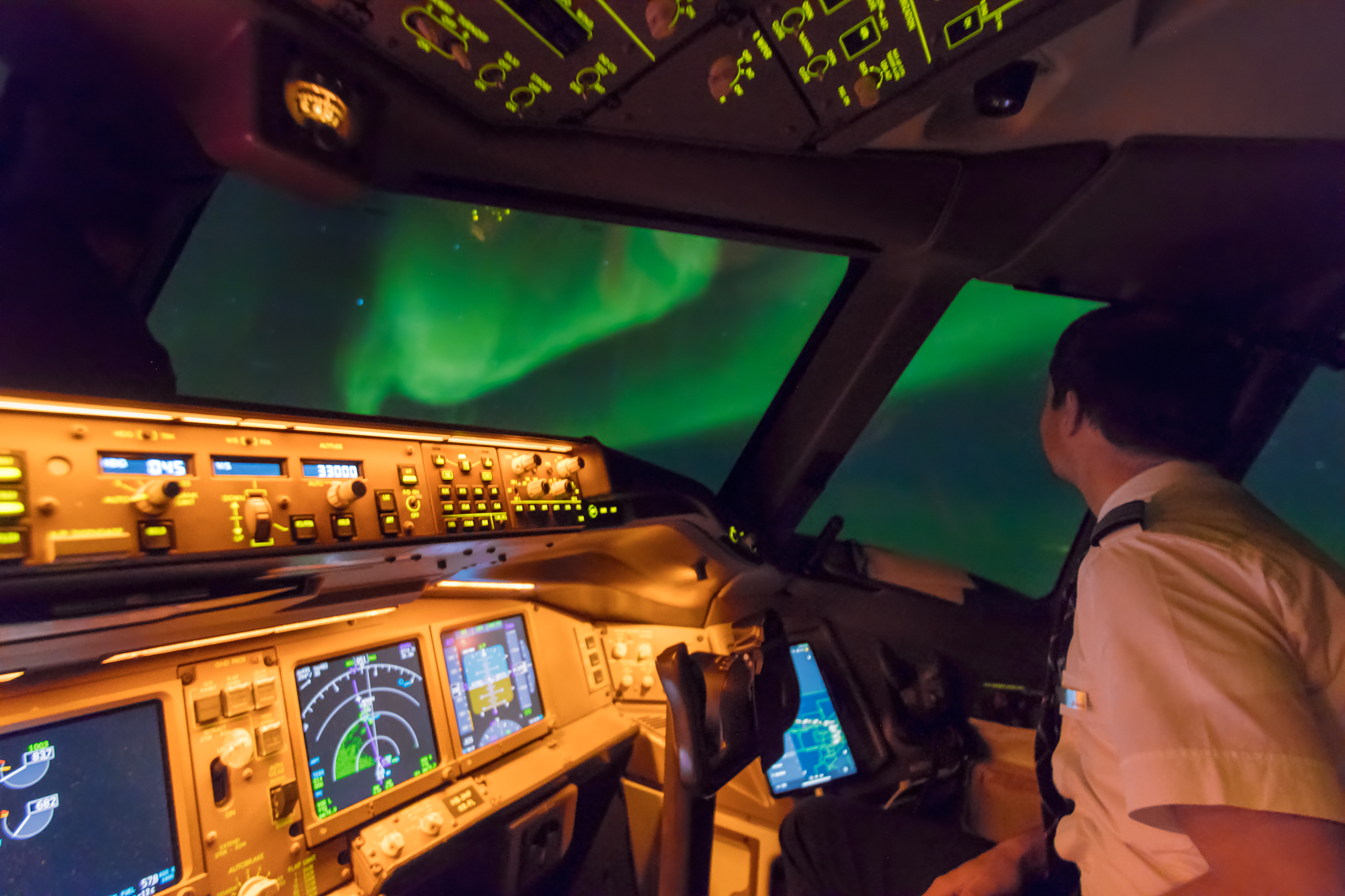 A photograph taken by pilot Ralf Rohner of a pilot watching the aurora from the cockpit