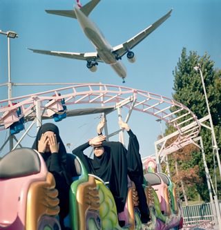 A plane flies low over students riding a train at a funfair over the weekend. Istanbul, Turkey, August 29, 2018. A plane flies low over students riding a train at a funfair over the weekend. Istanbul, Turkey, August 29, 2018.