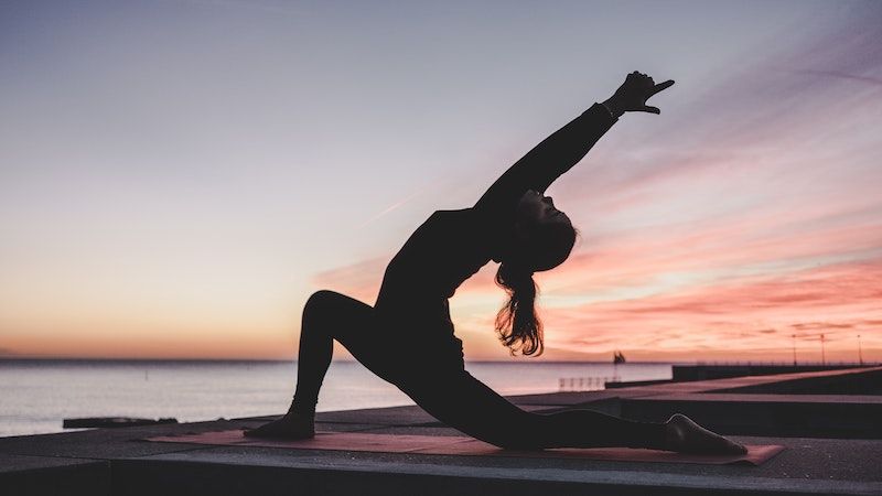 woman doing yoga on boardwalk