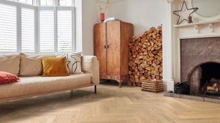 oak effect herringbone luxury vinyl flooring in living room with cream sofa