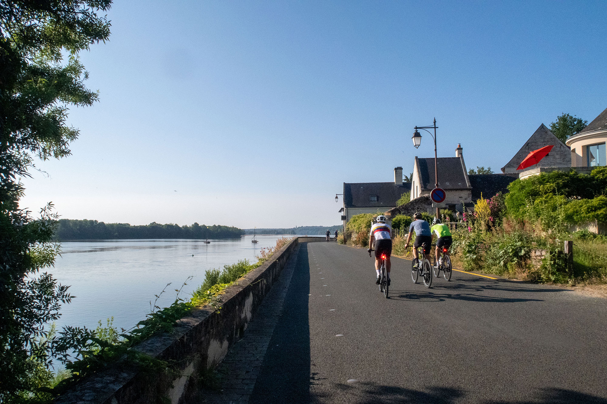 Three riders on road parallel to the River Loire, with rear lights clearly visible.