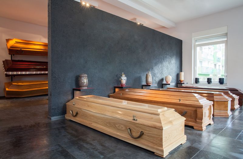 Coffins lined up on display at a funeral home.