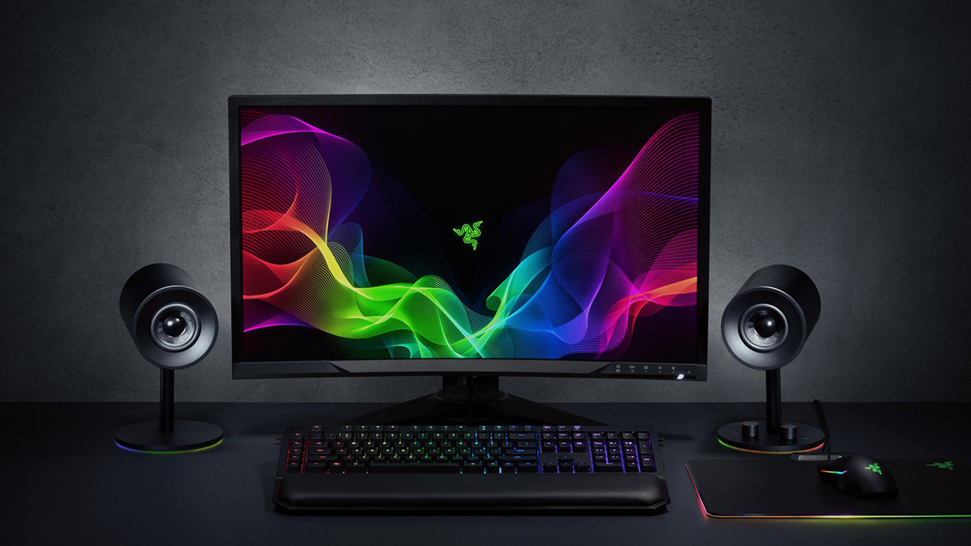 Razer Nommo Chrome speakers sitting on desk next to monitor and keyboard.